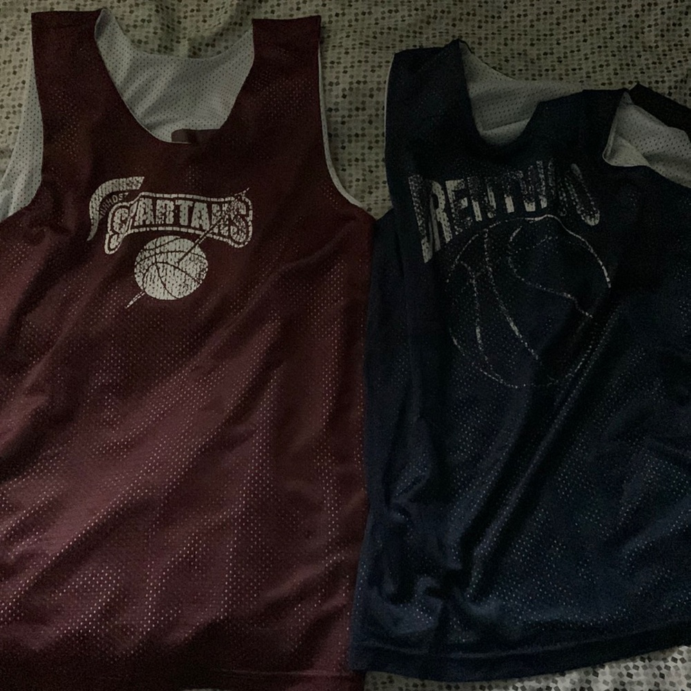 Two basketball jerseys both reversible one red and white one blue and white